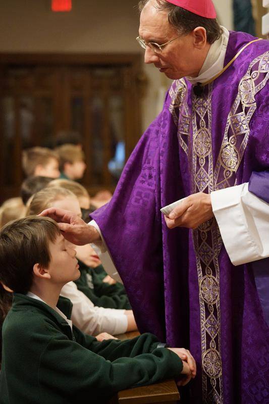 CHARLOTTE — Parishioners of St. Patrick Cathedral and students at St. Patrick School receive ashes from Bishop Peter Jugis during an 8:30 a.m. Mass on Ash Wednesday. (John Cosmas, Catholic News Herald)