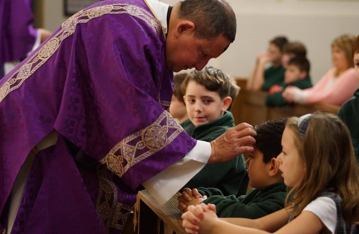 CHARLOTTE — Parishioners of St. Patrick Cathedral and students at St. Patrick School receive ashes from Bishop Peter Jugis during an 8:30 a.m. Mass on Ash Wednesday. (John Cosmas, Catholic News Herald)