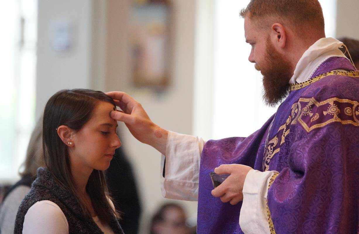 HUNTERSVILLE — St. Mark Church members receive ashes during a noon Mass at St. Mark Church.