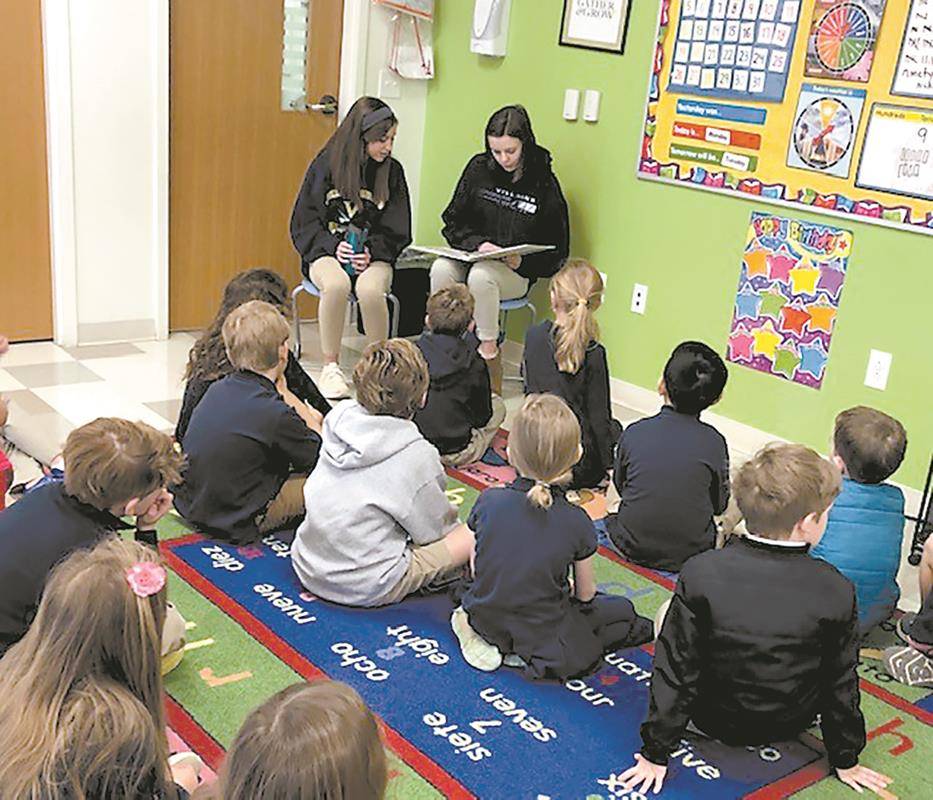 Bishop McGuinness High School alumni readers returned to St. Pius X School in Greensboro to read to the younger students. (Provided photo)