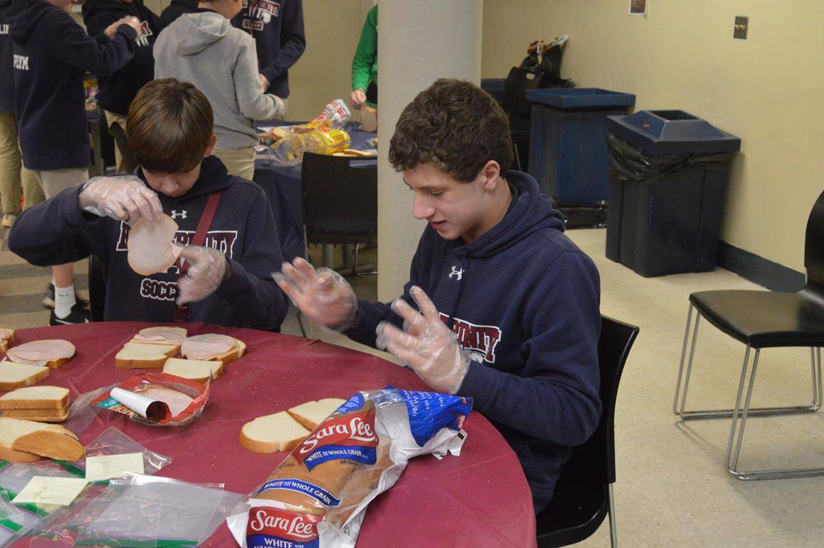 Eighth graders at Holy Trinity Middle School mads sandwiches as a service project for the homeless. (Photo provided by Lisa Michalski-Gilkey)