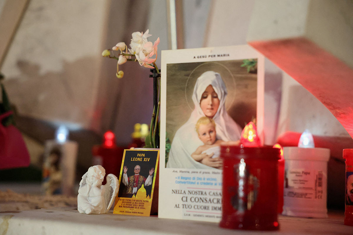 An image of Pope Leo XIV and other items are displayed outside Rome's Gemelli Hospital in the evening hours of Oct. 13, 2026, where the pontiff underwent surgery to remove a lung nodule. The Vatican announced that evening the surgery was successful.
