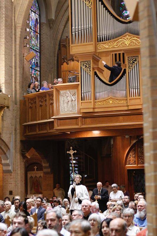 Father Buchanan's parents, Robert and Gloria Buchanan, bring up the offertory gifts at his installation Mass. (Photo by Barbara Markun)