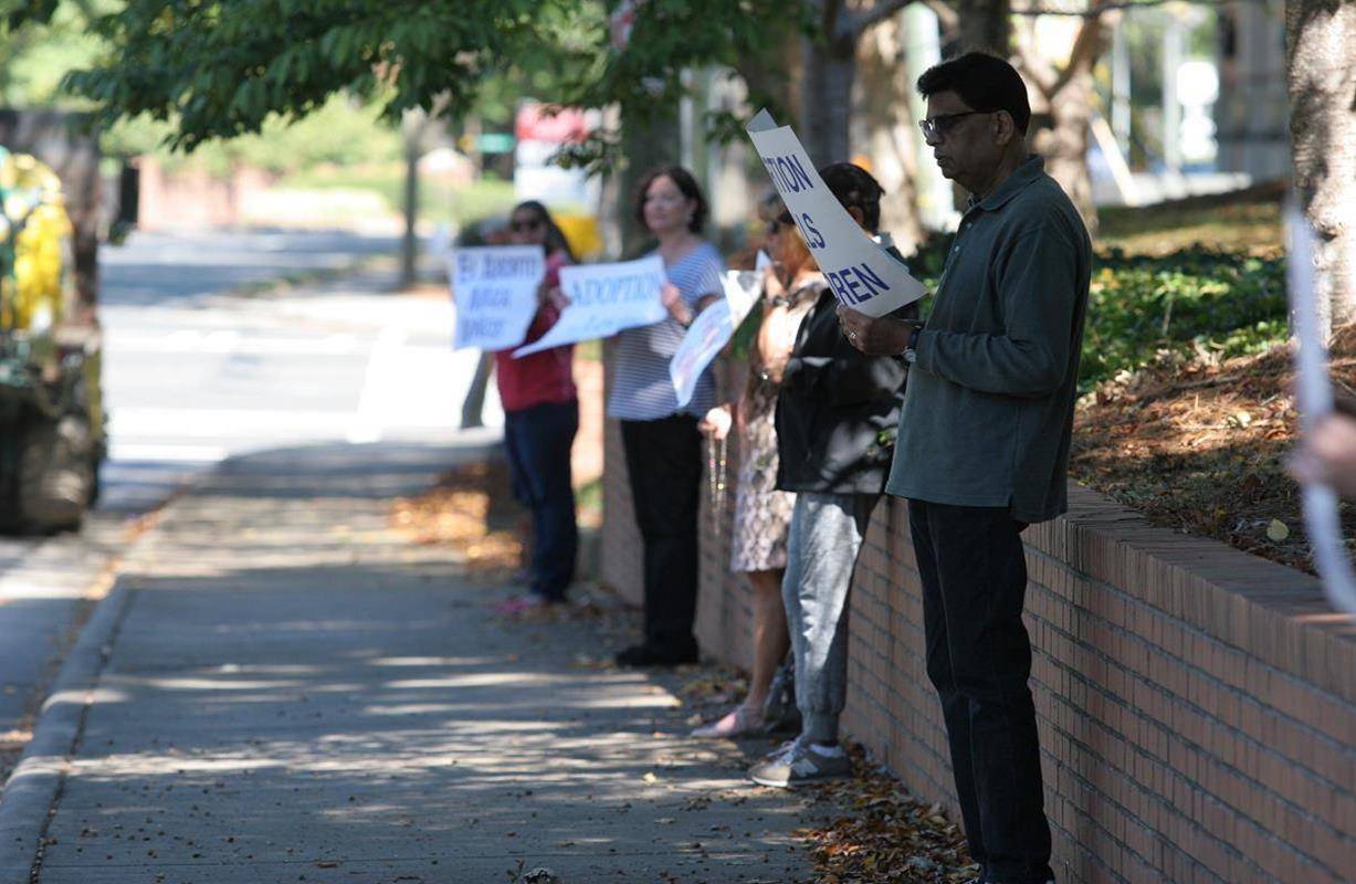 Parishioners of St. Gabriel Church in Charlotte pray with their pastor, Father Frank O'Rourke, along the sidewalk in front of the parish at the corner of Providence and Sharon Amity Roads. (SueAnn Howell, Catholic News Herald)