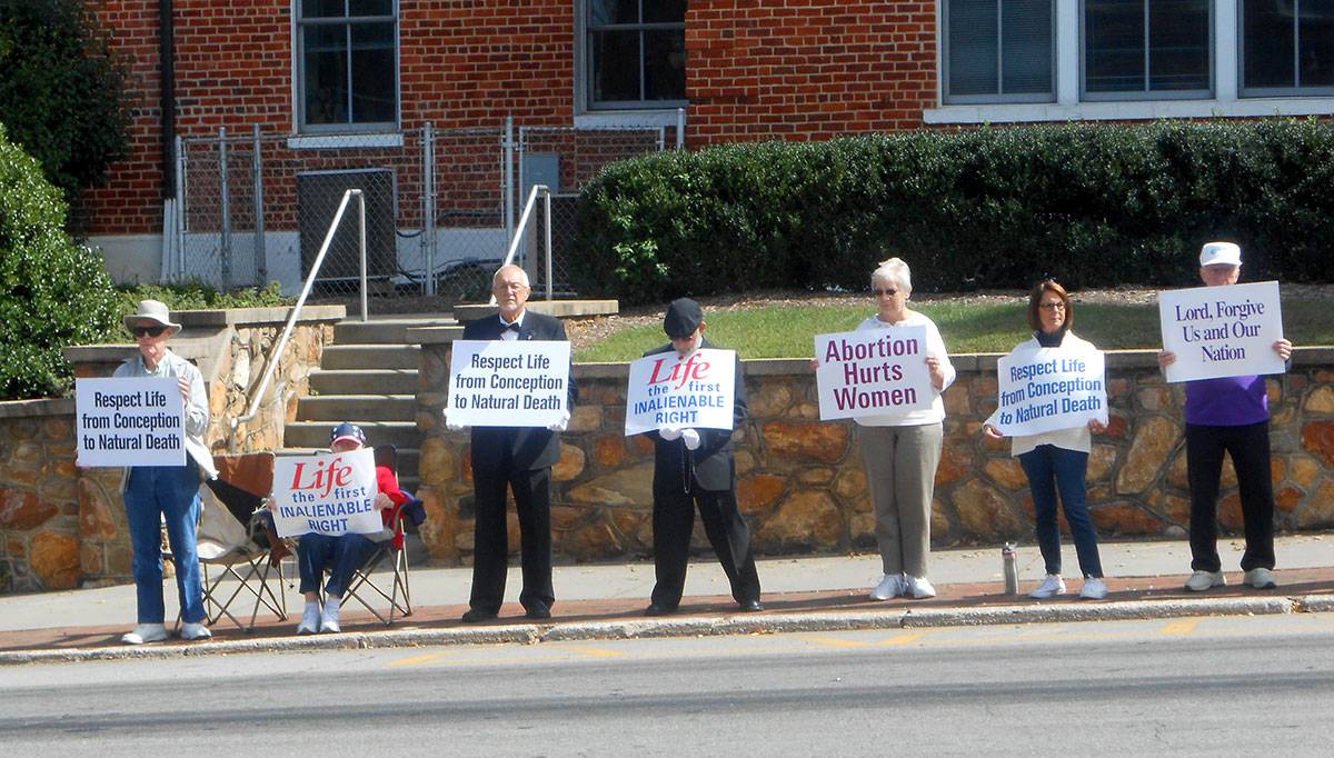 Holding pro-life message signs in Brevard.