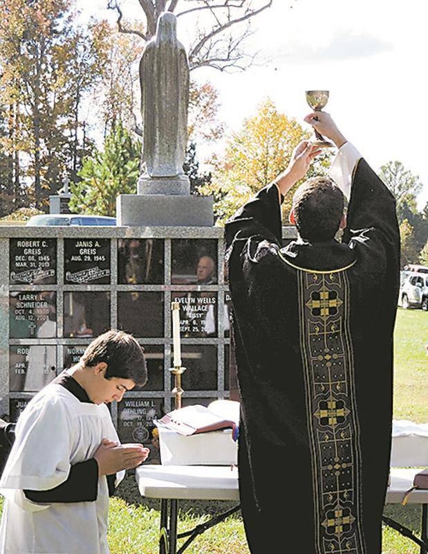 HUNTERSVILLE — Father Brian Becker celebrates an All Souls’ Day Mass at Northlake Memorial Gardens Cemetery.