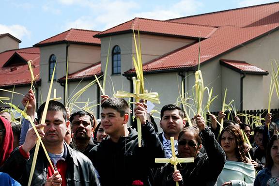BOONVILLE — Parishioners at Divine Redeemer Church, led by Father Jose Enrique Gonzalez-Gaytan, pastor, take part in a Palm Sunday procession outside the church March 25. (Sergio Lopez, correspondent)