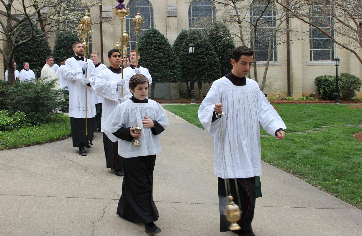 Altar servers and seminarians begin the procession into St. Patrick Cathedral at the start of the Chrism Mass March 27.
