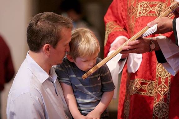 Parishioners at St. Patrick Cathedral venerate the cross. (Photo by SueAnn Howell, Catholic News Herald)