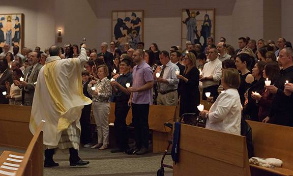 Father Pat Hoare, pastor, blesses the congregation with holy water during the Easter Vigil at St. Matthew Church in Charlotte.