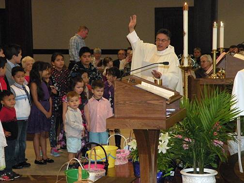 Father Alex Ajala, pastor, blesses the Easter baskets at Easter Mass at IHM in Hayesville (Photo by Vickie Ware, correspondent)