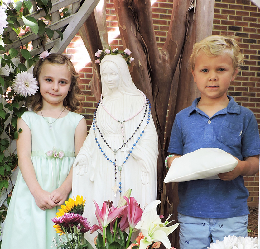 HUNTERSVILLE — St. Mark preschoolers brought flowers for their annual May Crowning Celebration May 4. One by one, the children gave their flowers to an image of the Blessed Mother in the parish’s Mary’s Garden, located outside the Adoration Chapel.