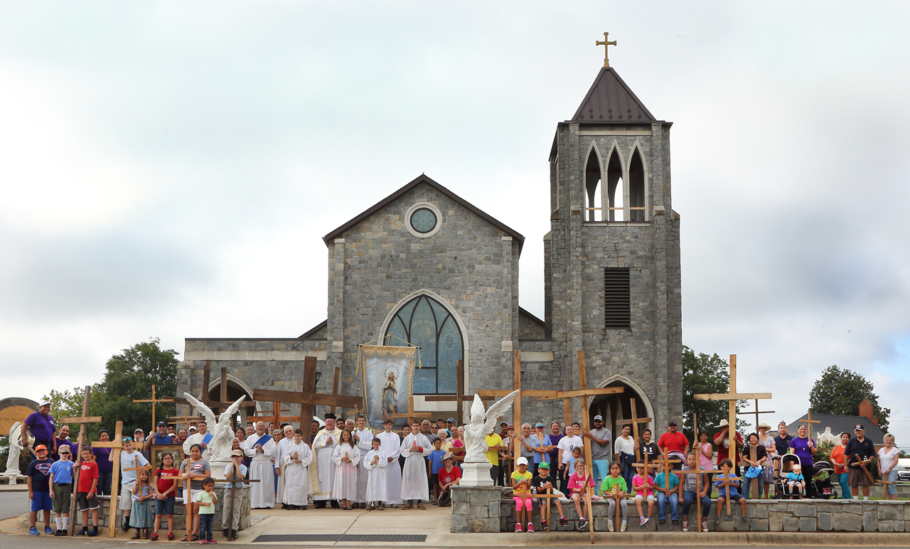 Cross-A-Thon participants pose for a group photo in front of Immaculate Conception Church.