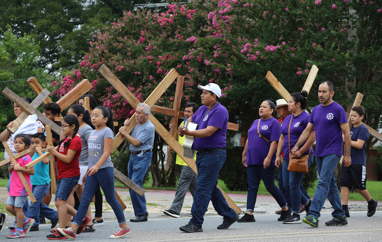 Participants walk and sing hymns along the one-mile procession route on Main Street in Forest City.
