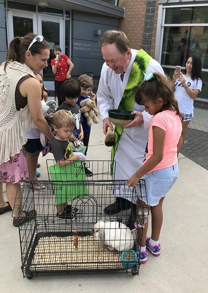 Immaculate Heart of Mary Church’s Deacon Wally Haarsgaard presided over a prayer service and blessing. Children brought animals on leashes and in cages to be blessed, while others brought their favorite stuffed animals. (Photo provided by Carrie Vest) 