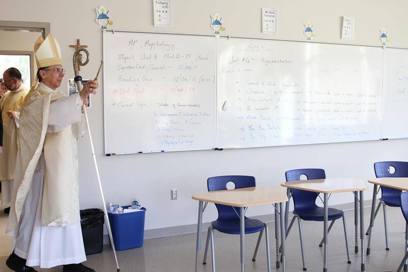 Bishop Peter Jugis blesses one of the new classrooms in the 27,000 square-foot addition.