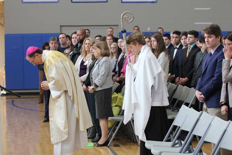 Bishop Peter Jugis reverences the altar at the beginning of Mass Dec. 6.