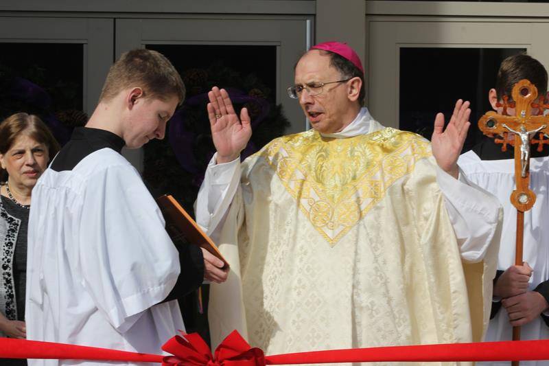 Bishop Peter Jugis offers prayers of blessing before the ribbon cutting.