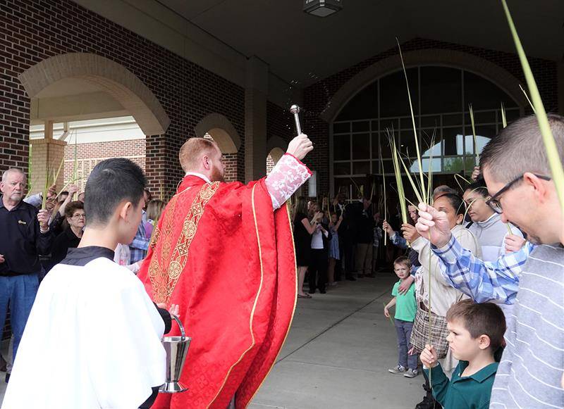 Father Noah Carter, parochial vicar, blesses the faithful during Palm Sunday Mass at St. Mark Church in Huntersville. (Photos provided by Amy Burger)