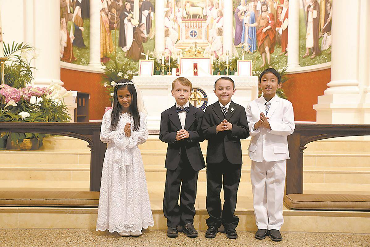 Four children, Katie Albert, Søren Hren, Luke Lewis and Justin Kuncoro, celebrated their first Holy Communion during a Mass in the Extraordinary Form at St. Ann Church in Charlotte earlier this month. (Photo provided by Markus Kuncoro)