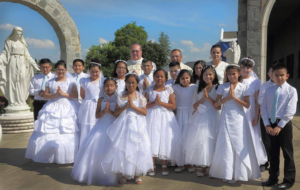 Seventeen children of the Hispanic community of Immaculate Conception Church in Forest City received first Holy Communion May 19 during a Spanish Mass concelebrated by Father Josè Antonio Juya and Father Herbert Burke. (Photos by Giuliana Polinari Riley)