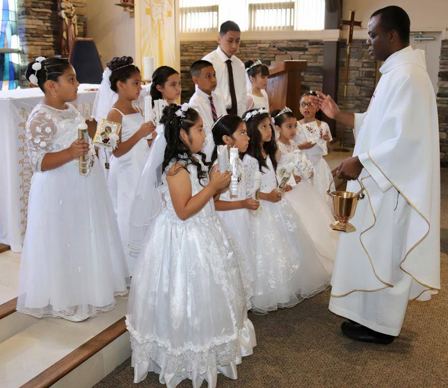 Children at Our Lady of the Rosary Church received their first Holy Communion during three Masses in May offered by Father Ambrose Akinwande, MSP, pastor. (Photos provided by Julia Fredrica Foy Michaels)