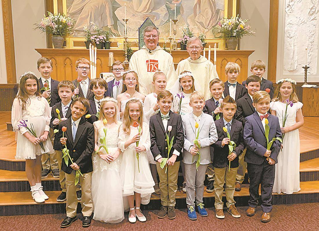 Children at St. Peter Church in Charlotte received their first Holy Communion during two Masses offered May 4 by Jesuit Father Jim Shea, pastor, and Jesuit Father John Michalowski, parochial vicar. (Photos provided by Cathy Chiappetta)