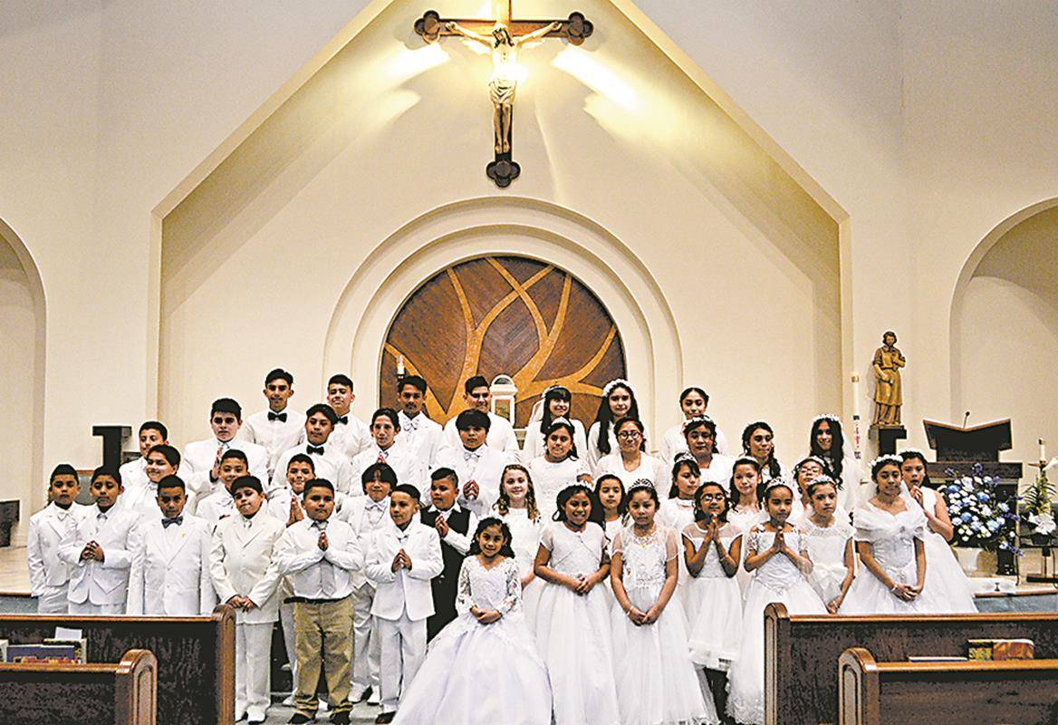 After each of the Masses, one of the First Communicants crowned a statue of the Blessed Mother and the rest processed behind, bringing up blue and white carnations to make a bouquet. (Photos provided by Connie Ries)