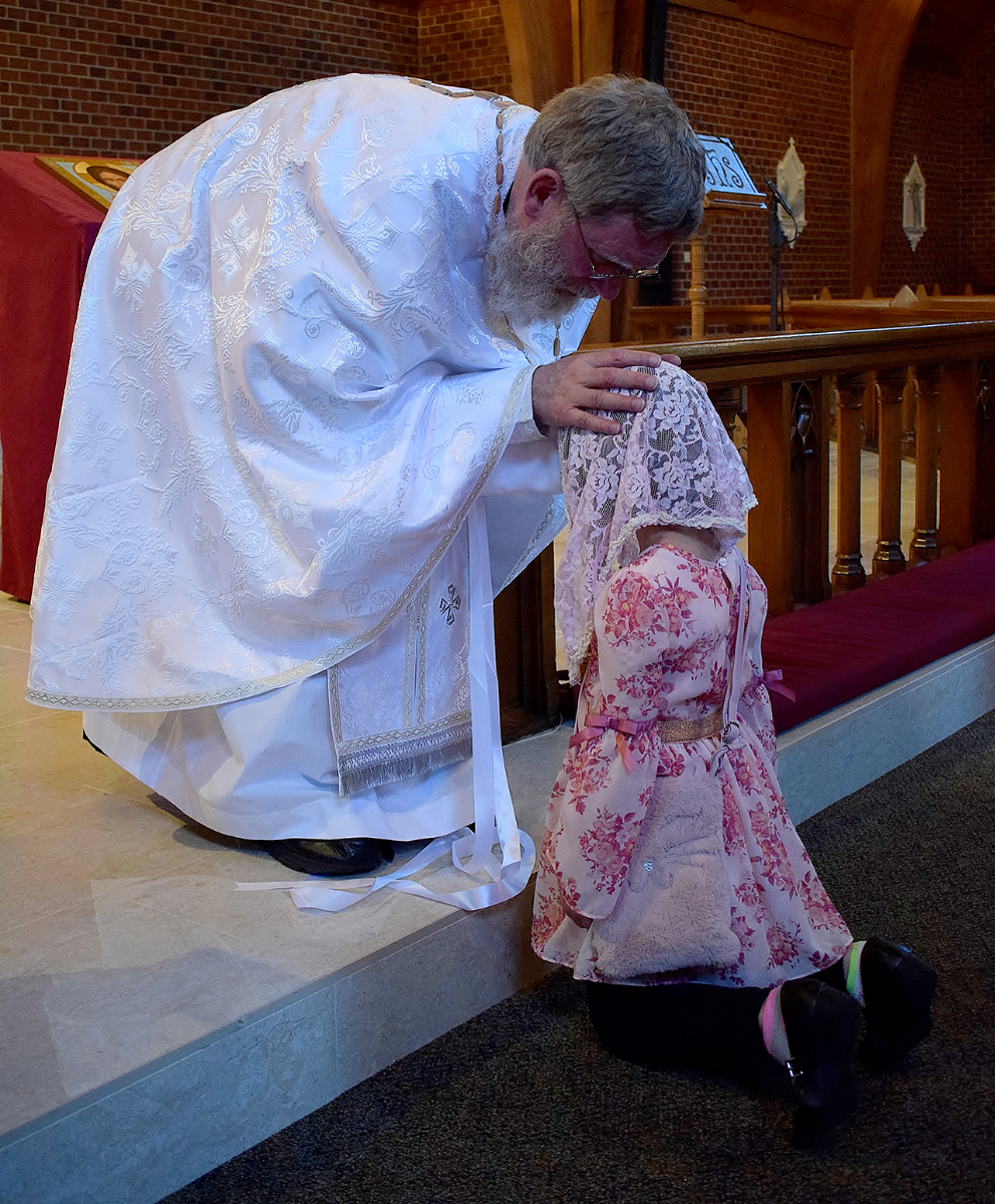 Father Kevin gives his first blessing to his goddaughter. (Della Sue Bryson)