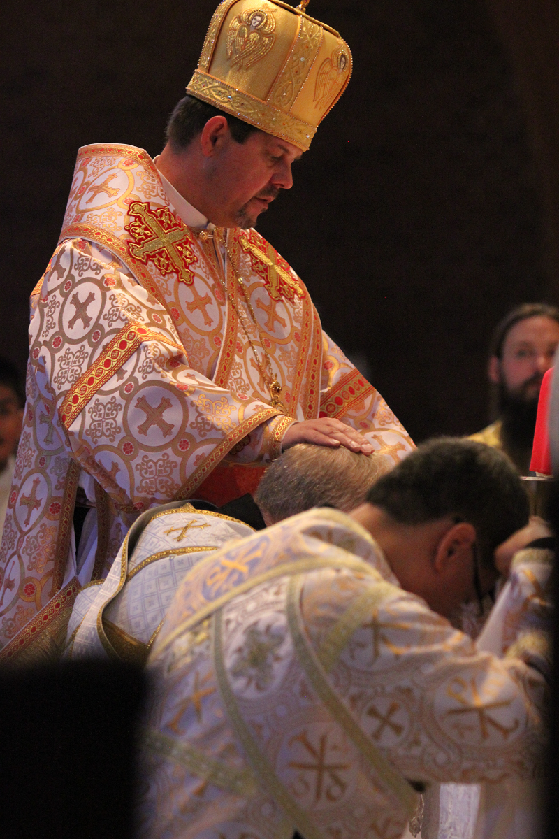 Bishop Bohdan Danylo lays hands on deacon candidate David Rinehart while Basilius Magnus also kneels before the altar during their diaconate ordination June 16.