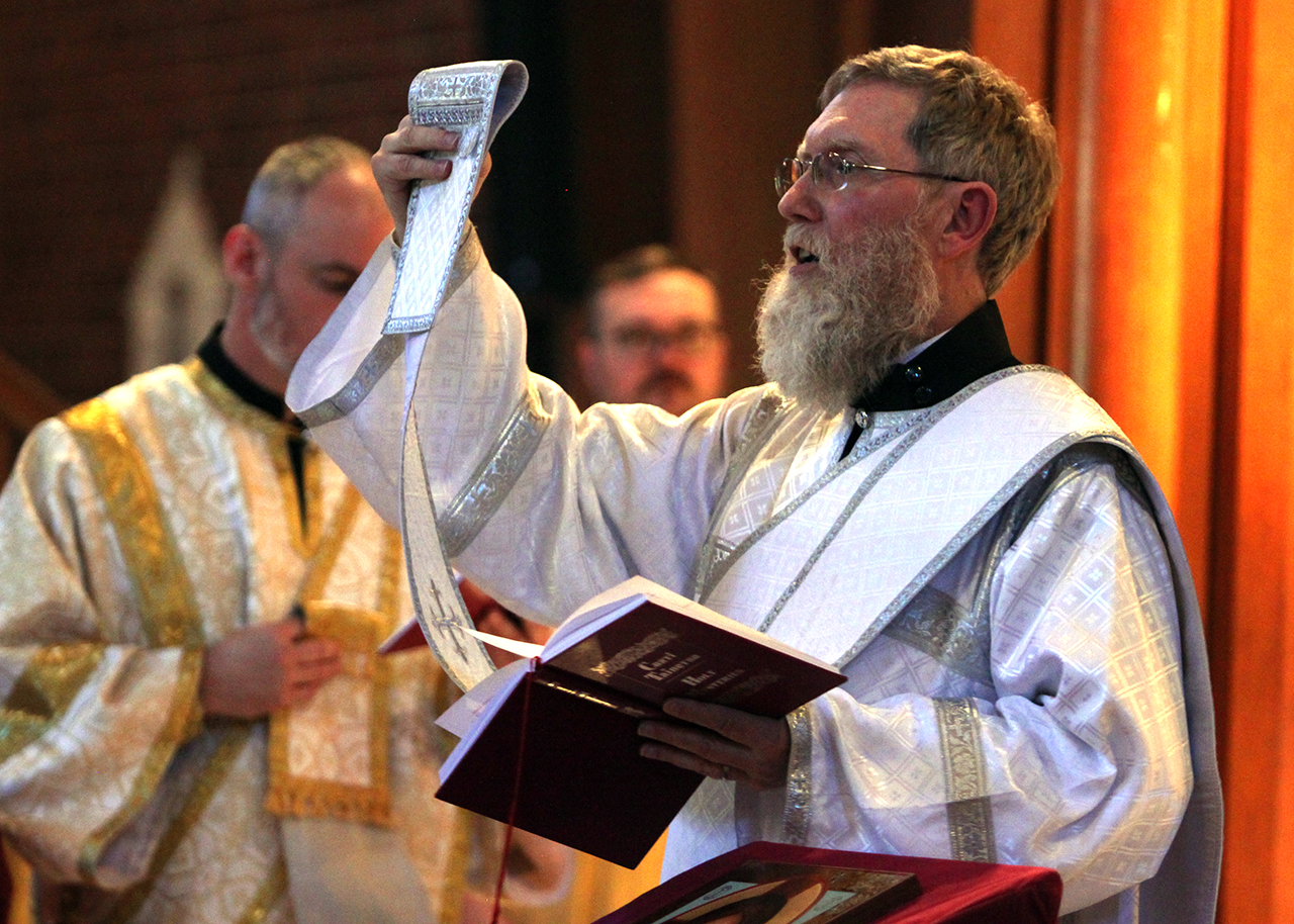 Deacon Kevin holds up his orarion, or diaconal stole, while chanting during the Divine Liturgy.