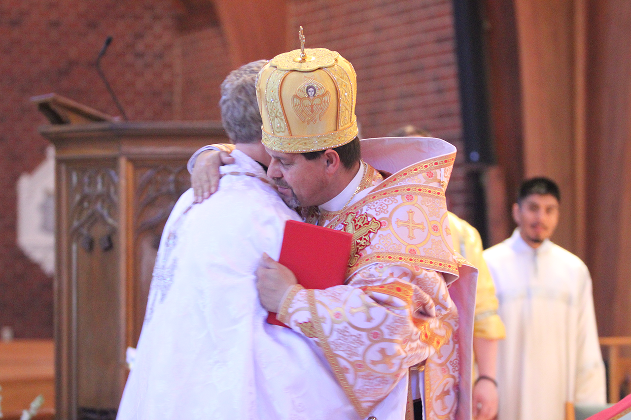 After giving the new priest the Liturgicon (the red book, pictured), Bishop Bohdan exclaims 