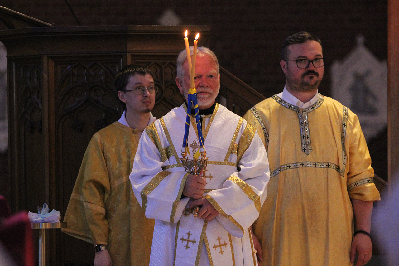 David Rinehart carries the dikirion, a two-pronged candle that symbolizes the dual nature of Christ as God and Man.