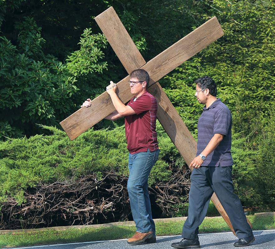 Taking turns carrying the heaviest cross.