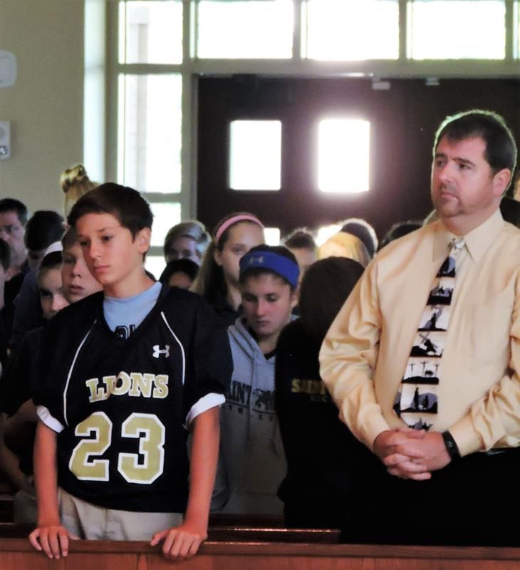 8th Grader Charlie Boone with religion teacher Larry Storace