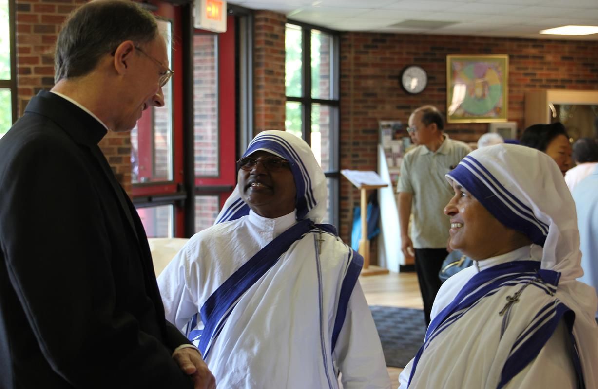 Bishop Peter Jugis talks with two of the Charlotte Missionaries of Charities