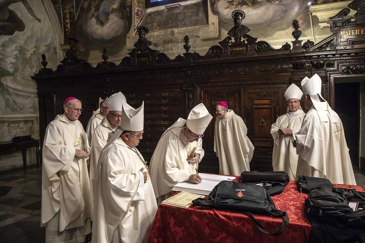 Bishop Robert E. Guglielmone of Charleston, S.C., signs a guest book as U.S. bishops from Florida, Georgia, North Carolina and South Carolina prepare to concelebrate Mass at the Basilica of St. John Lateran in Rome Feb. 10, 2020. 