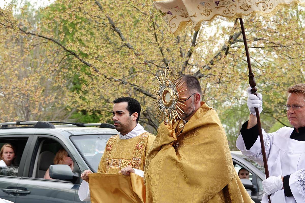 Father John Putnam, pastor, leads a Eucharistic procession outside St. Mark Church in Huntersville during Holy Week. (Photo provided by Amy Burger)