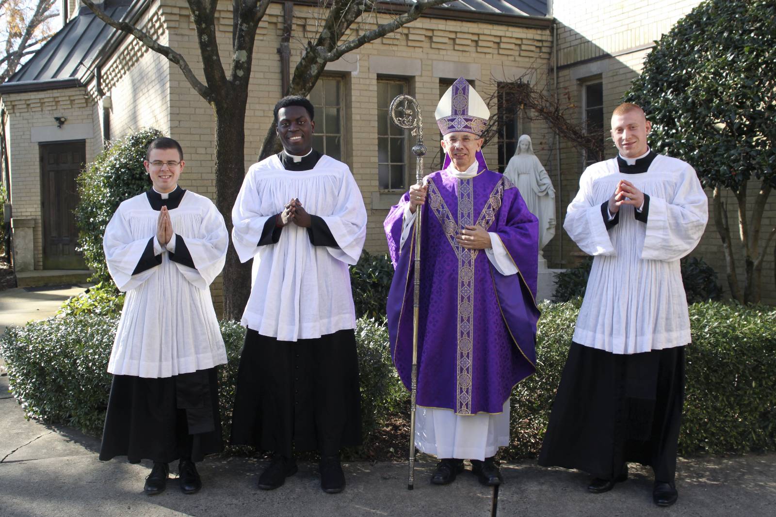 (From left) Seminarians Christopher Brock, Chinonso Nnebe-Agumadu and Peter Rusciolelli stand with Bishop Jugis after being instituted as lectors, one of the steps in their formation to the priesthood.