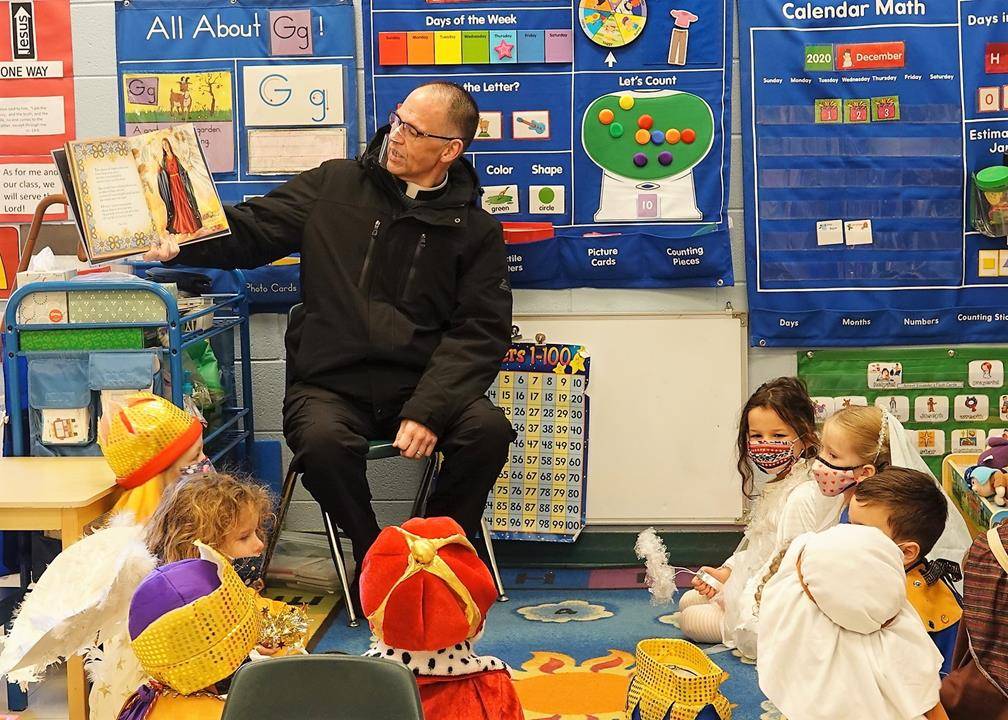 Before their performances, Father John Putnam, pastor of St. Mark Church, read to the children, (Photos provided by Amy Burger)