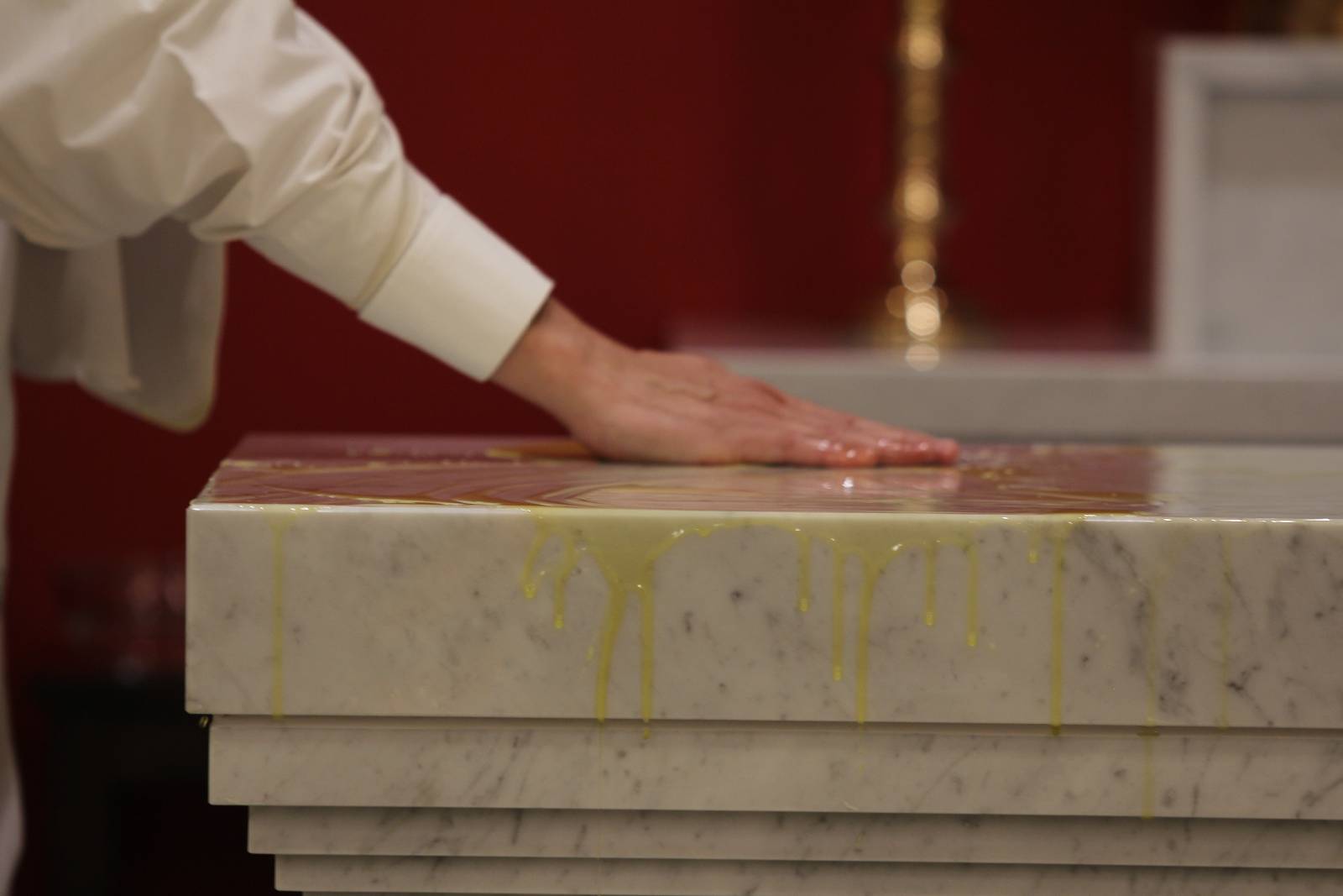 The sacred oil, blessed during the annual Chrism Mass at St. Patrick Cathedral, is rubbed over the top of the new altar by Bishop Peter Jugis during the dedication rite Jan. 27.