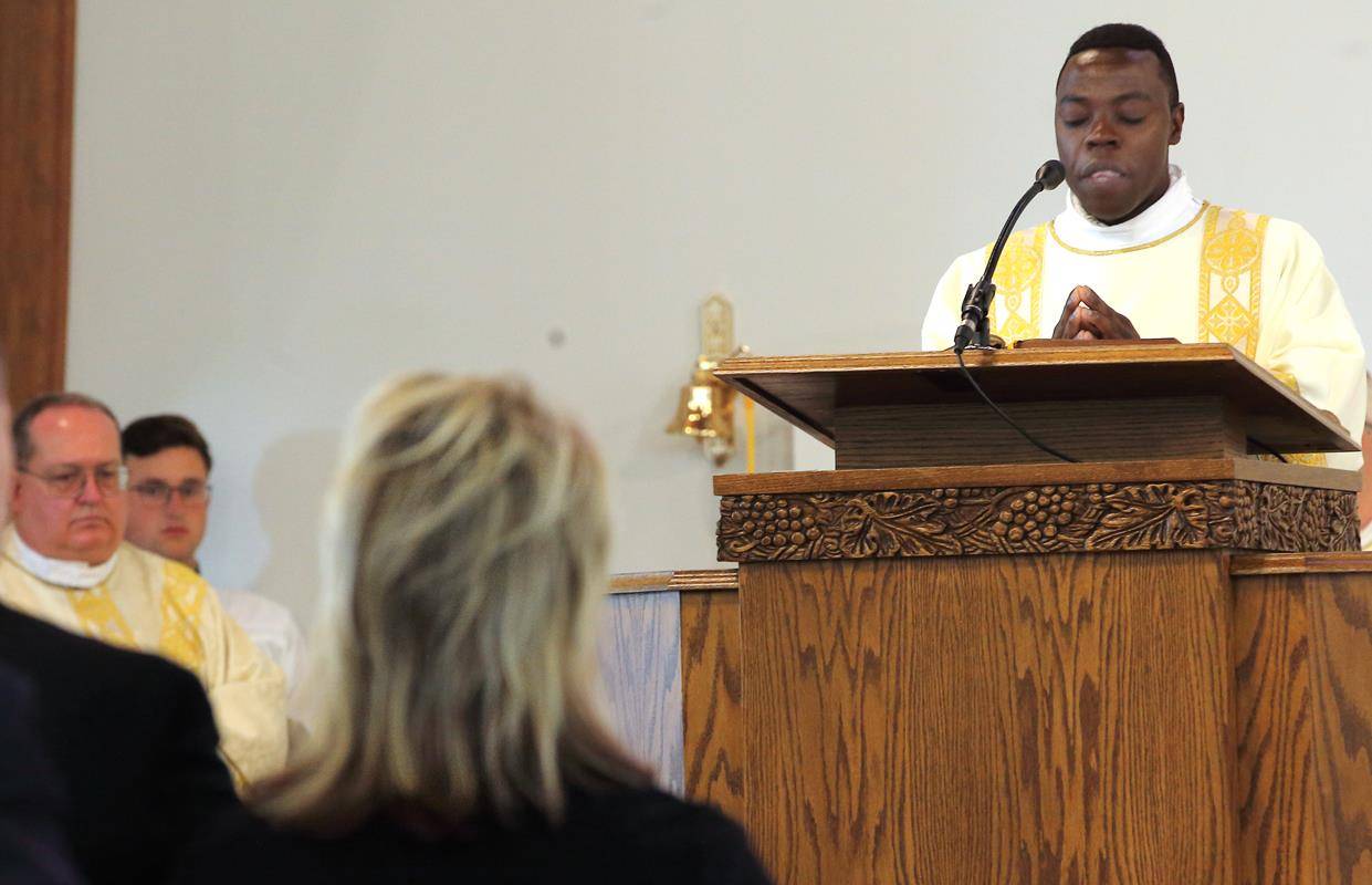 Deacon Joseph Wasswa proclaims the Gospel, a reading from Luke 24:13-35.