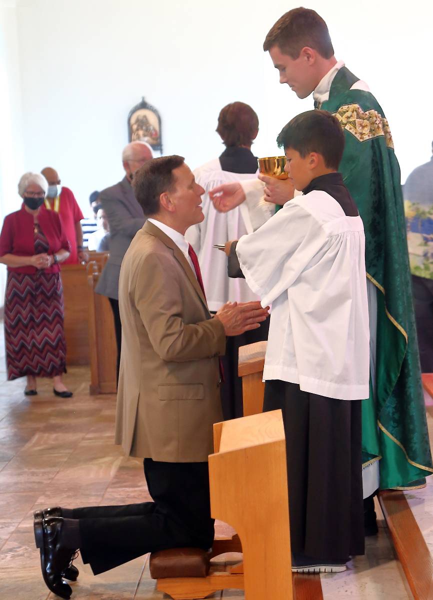 Father Ascik gives Holy Communion to his father.