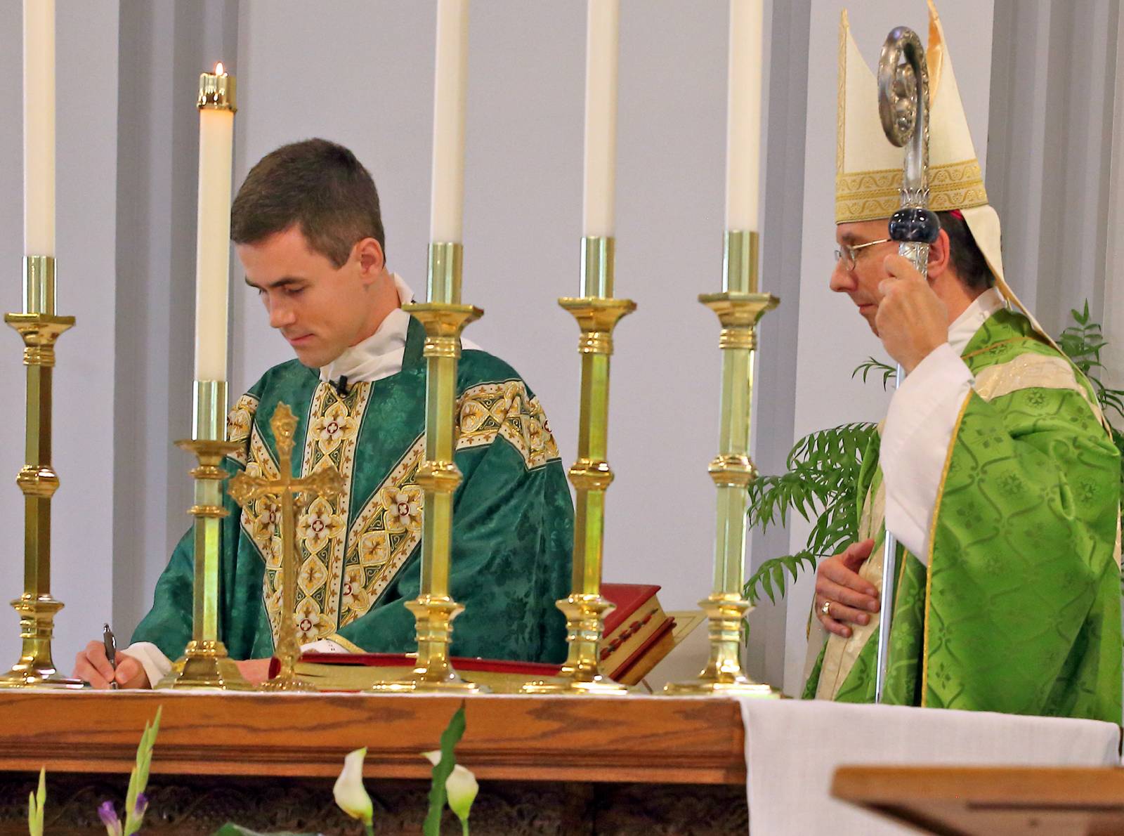 Father Ascik signs the Oath of Fidelity in the presence of Bishop Peter Jugis.