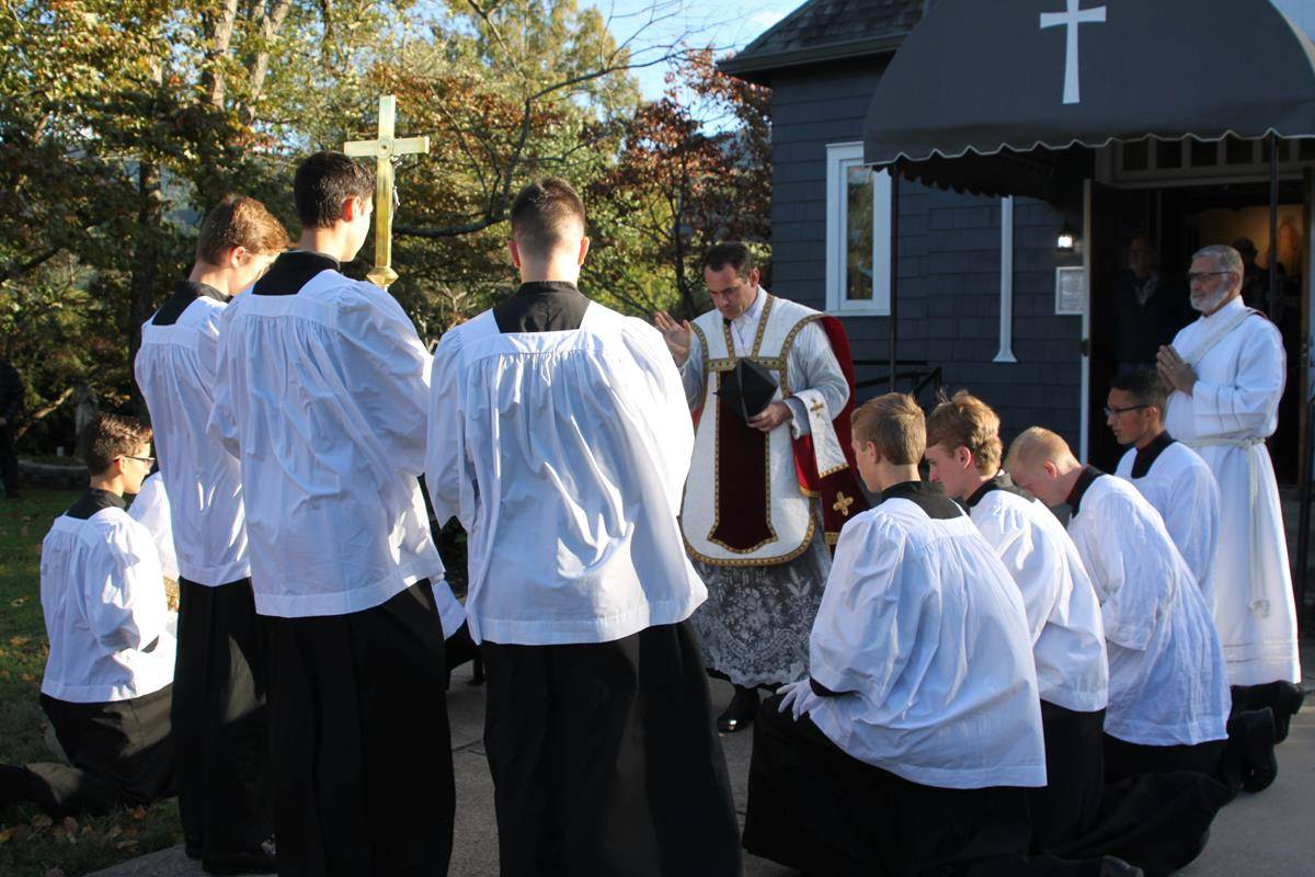 Additional attendees took advantage of the pleasant weather to gather on the church grounds for the Mass, receiving Communion from Father Becker at the front door.