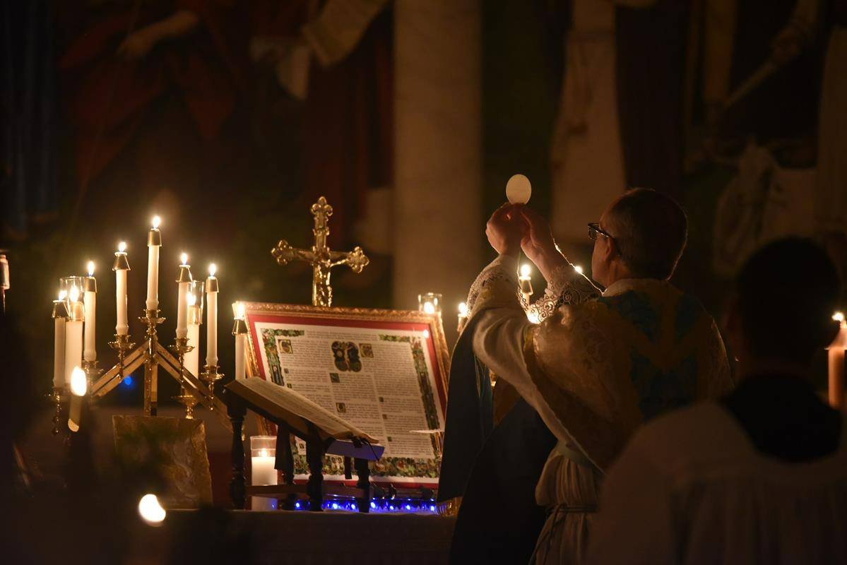 St. Ann Church in Charlotte hosted an annual Rorate Mass in honor of Our Lady Dec. 11. Fr. Timothy Reid, pastor, celebrated the Mass. He was assisted by Deacon Peter Tonon and seminarian Nick Kramer, who served as subdeacon. (Photo by Markus Kuncoro)