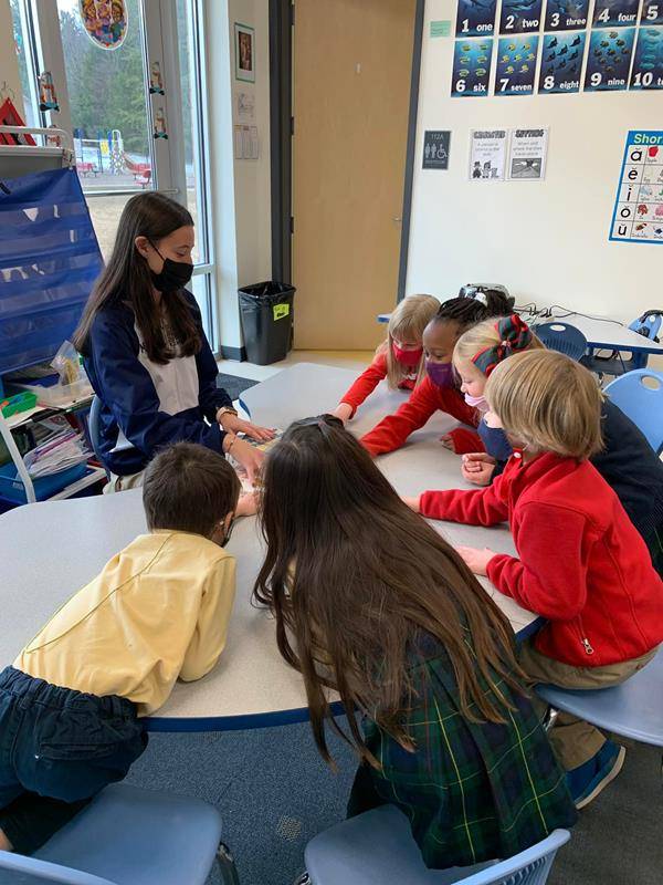Bishop McGuinnes High School students and alumni read to younger students