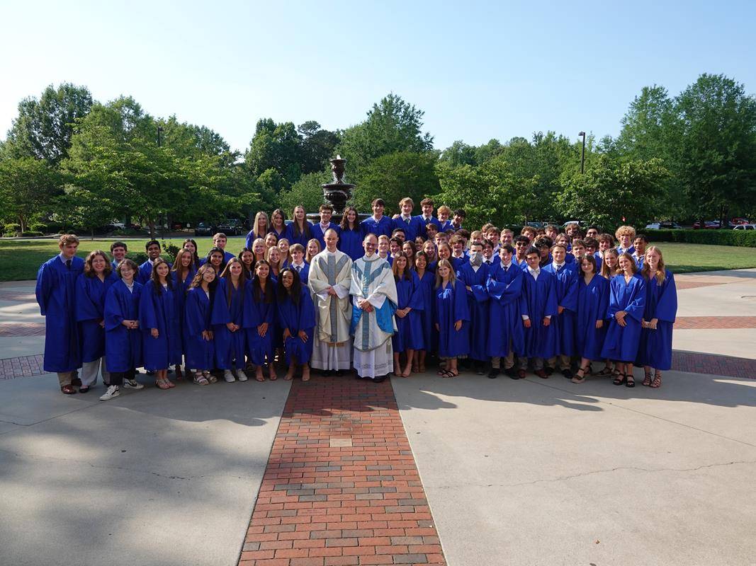 The Christ the King High School Class of 2022 is pictured with (center, from left) Father Michael Carlson and Father John Putnam after the baccalaureate Mass celebrated on May 31 at St. Mark Church in Huntersville. 