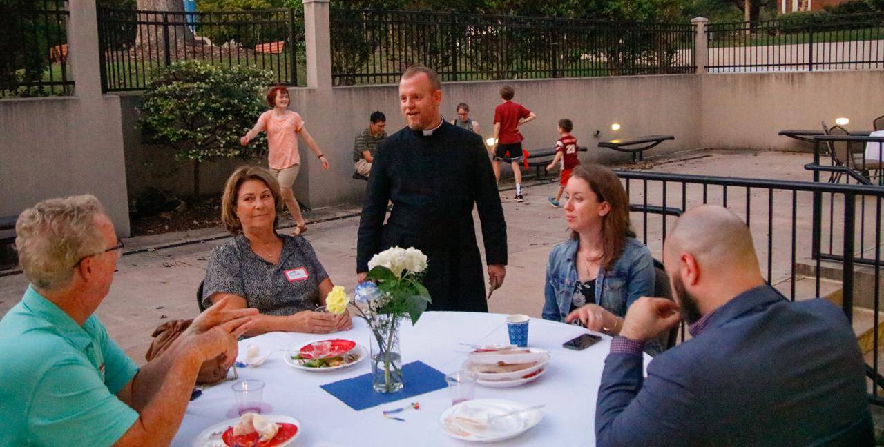 Father Casey Coleman visits with parishioners on the terrace.