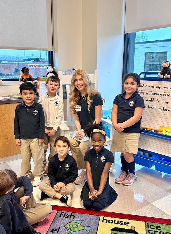 St. Pius X alumna Sophia Hill reads to Laura Collins’ kindergarten class.
